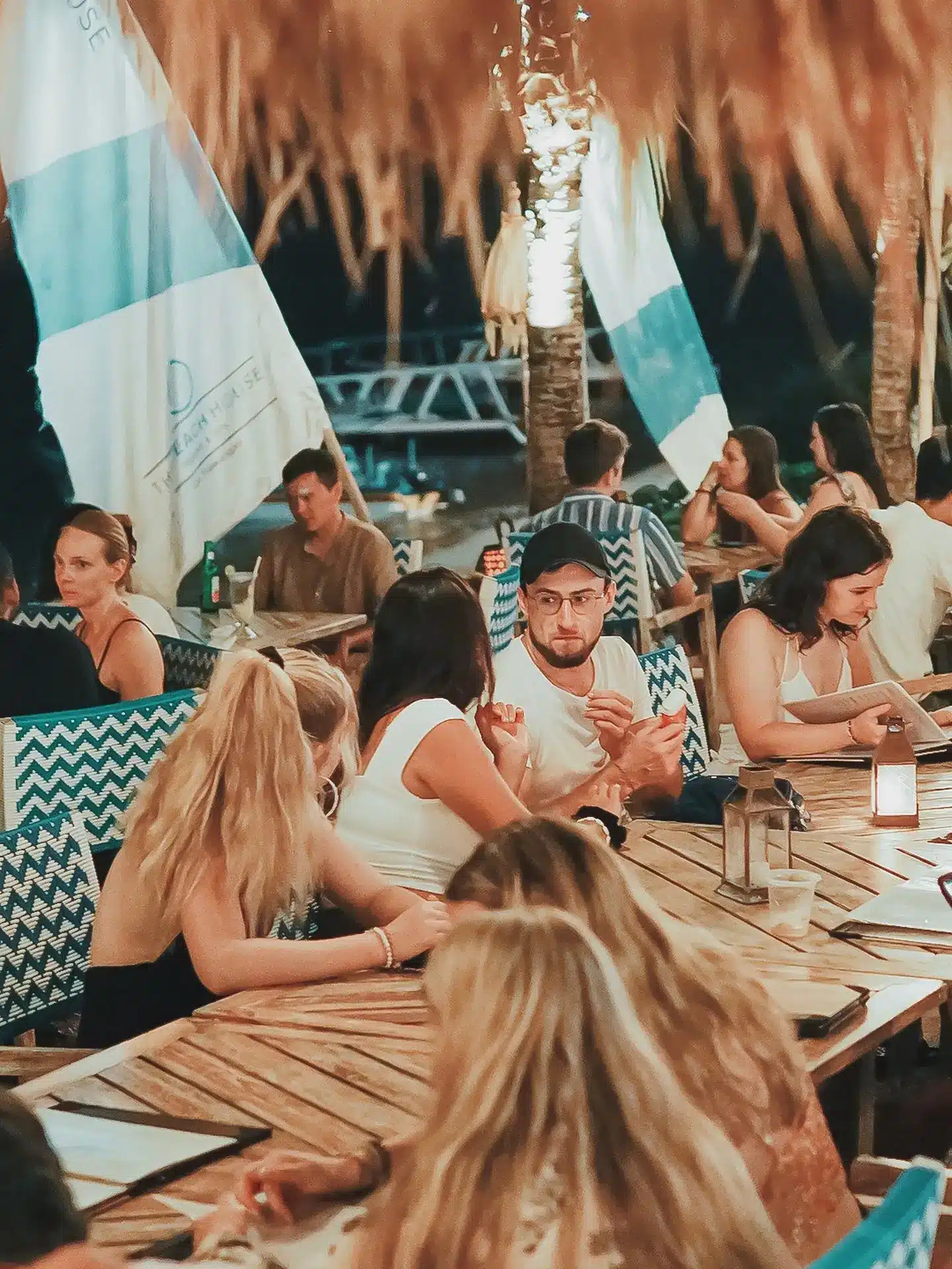 Visitors enjoying dinner and conversation at a beachfront restaurant in Gili Trawangan.