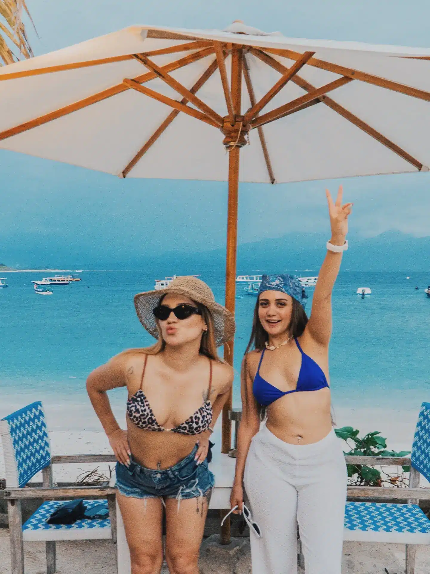 Two visitors enjoying a spontaneous beach moment by the ocean in Gili Trawangan.